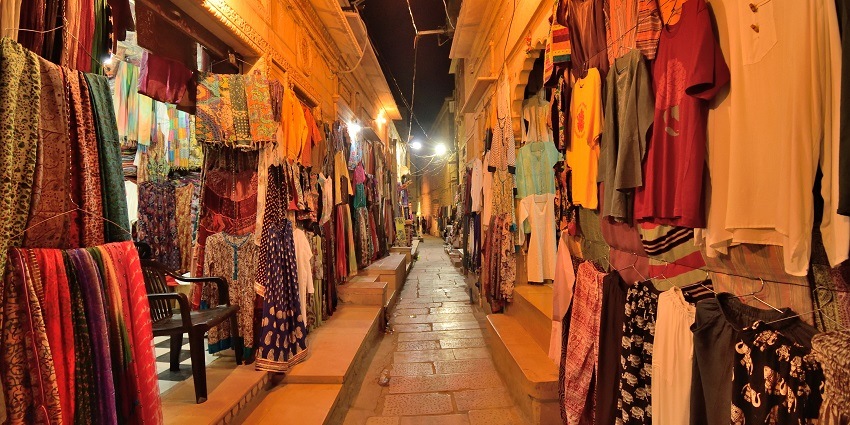 View of a narrow street at night, selling traditional Gujarati clothes