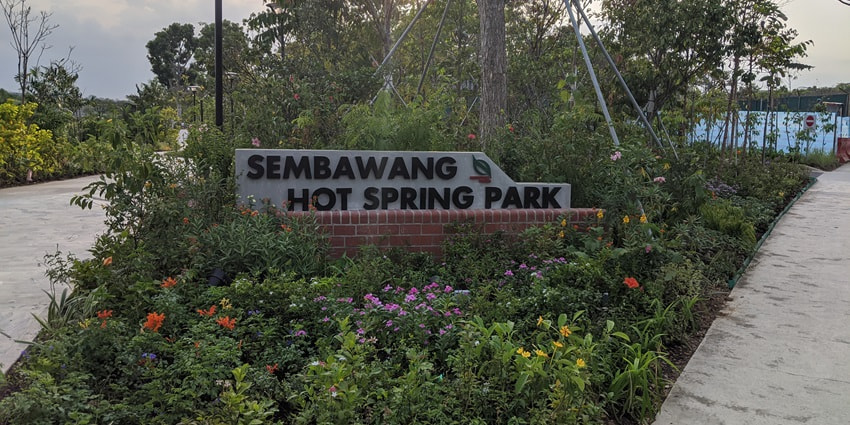 A picture of the entrance of the Sembawang Hot Spring Park with flowers all around