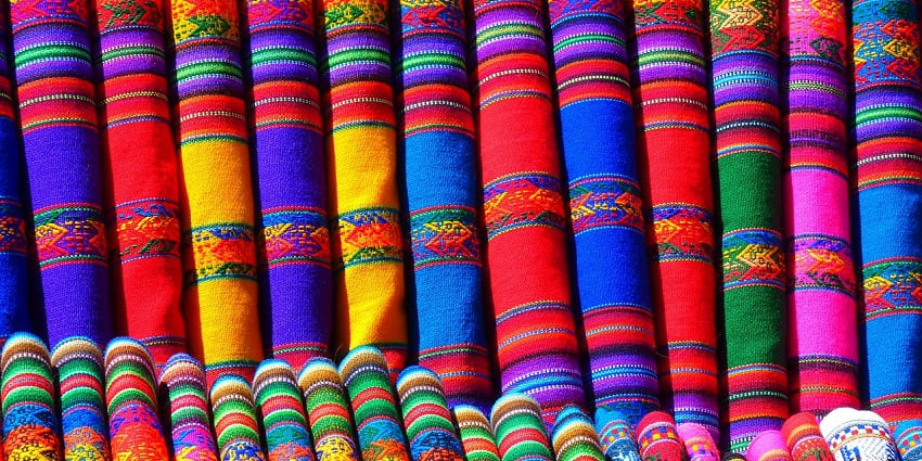 Close-up of colourful Cambaya fabric, displaying intricate patterns and vibrant colours, representing traditional textile shopping in Ahmedabad.