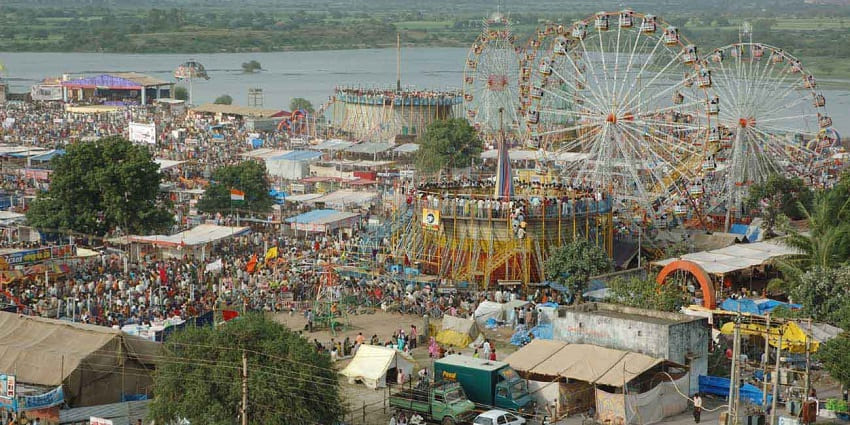 Aerial view of the fair, with vibrant shops, ferris wheel and small eateries and stalls
