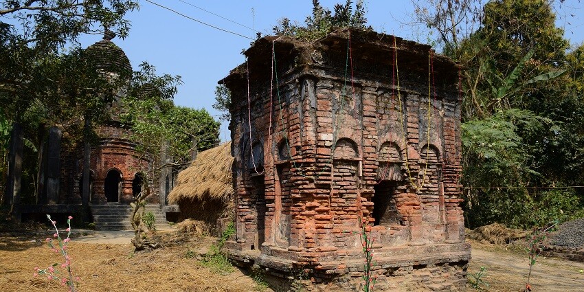 A scary view of an abandoned house with broken walls and windows during the day.