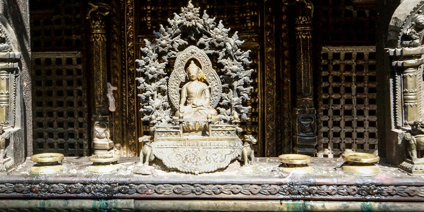 A golden and silver sculpture of Buddha statue displayed in the Shanichara Temple.