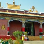 A peaceful view of Shechen monastery in Bodhgaya, Nepal, India, surrounded by trees.