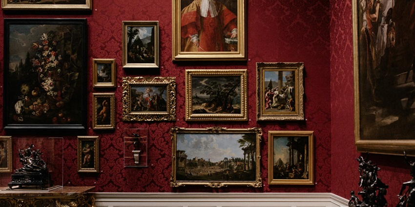 Assorted picture frames of various sizes and shapes arranged on a white wall.