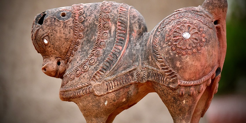 A traditional figurine featuring intricate artwork showcased in the region of Shilpgram.