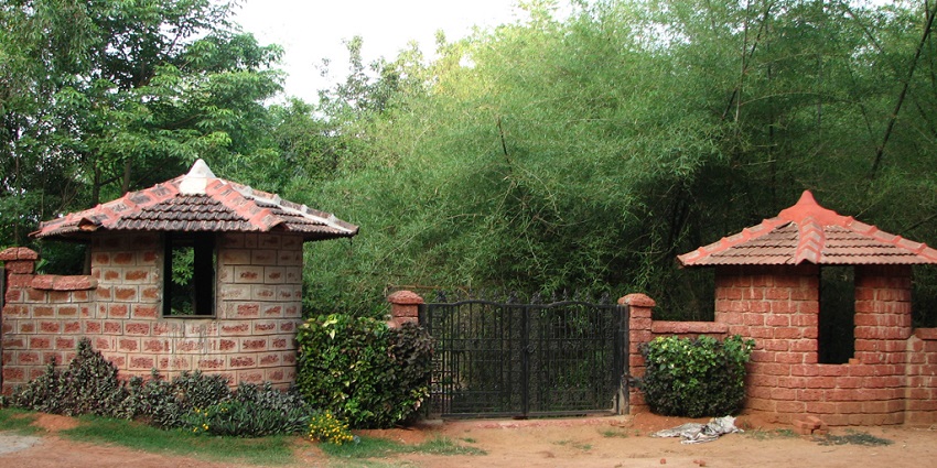 Rajasthani village setup at Shilpgram, featuring mud huts and artisanal displays.