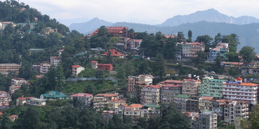 A majestic view of the settlement of Shimla with lush greenery and hill houses visible all around