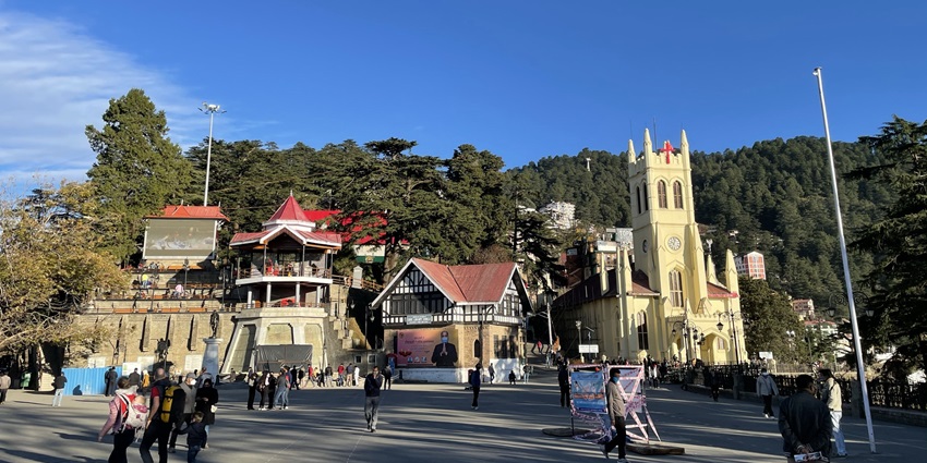 Image of The Ridge, Shimla surrounded by lush green mountains and people exploring