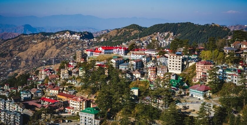 A breathtaking aerial view of Shimla with a lot of houses, mountains and lush greenery.