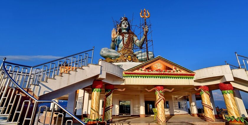 Shiva statue in Pumdikot, reflecting the Shiva temples in Nepal, with a clear blue sky and mountains.