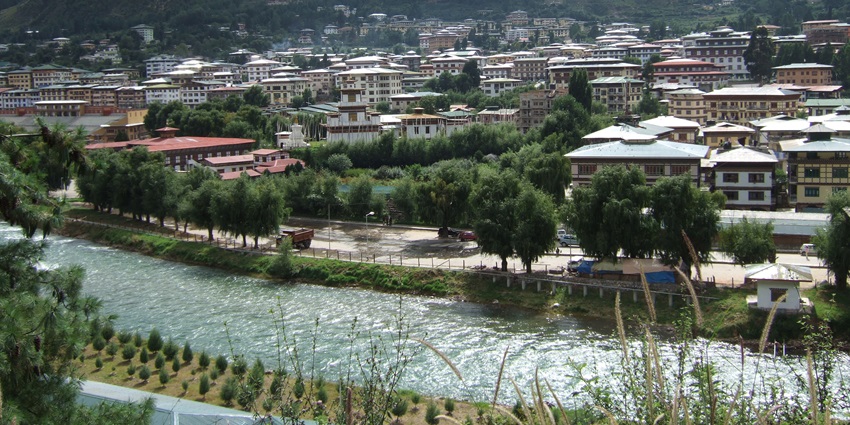 View of Thimphu city center from across river with mountains in background, Bhutan