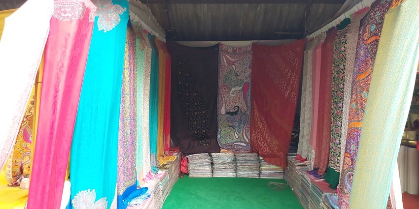 Saree shop interior at Shilparamam with colorful hanging sarees and folded stacks