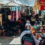 A stunning view of a street lined with assorted clothes with a woman walking through.