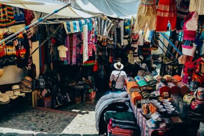 A stunning view of a street lined with assorted clothes with a woman walking through.