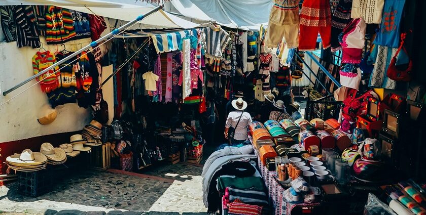 A stunning view of a street lined with assorted clothes with a woman walking through.