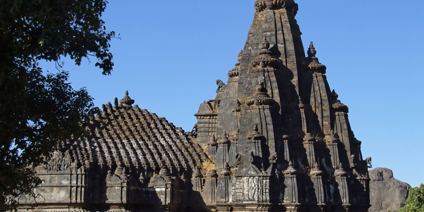 Image of a temple with ancient architecture and lush green surroundings