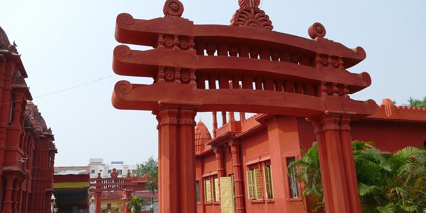 The entrance to the Shree Parshwanath Jain Derasar temple made of red colored stones.
