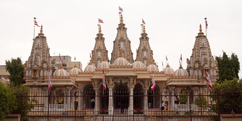Wide angle shot of the temple, the carved top and a flag flapping above it