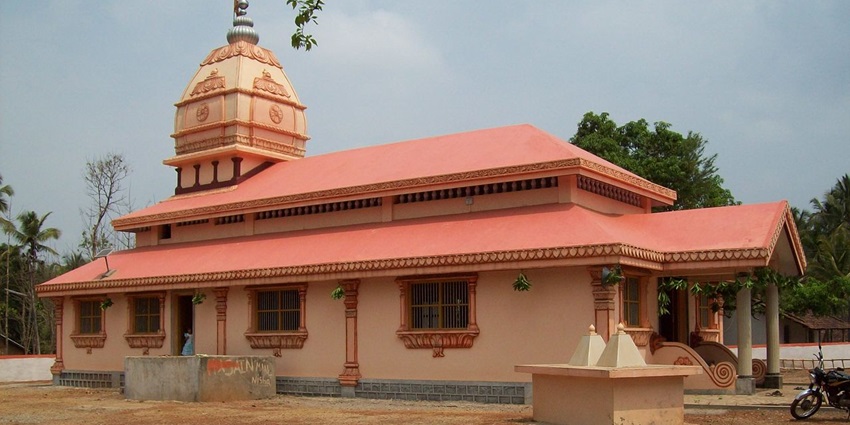 A picture of the exterior of a temple in Akkalkot with a hut-like architecture and orange-painted walls