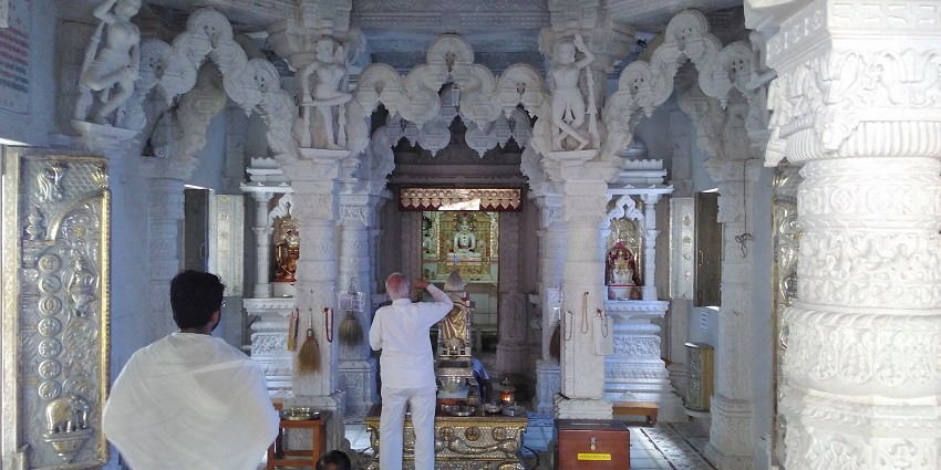The Shree Vasupujya Jain derasar features god idols and intricate carvings of the temple.