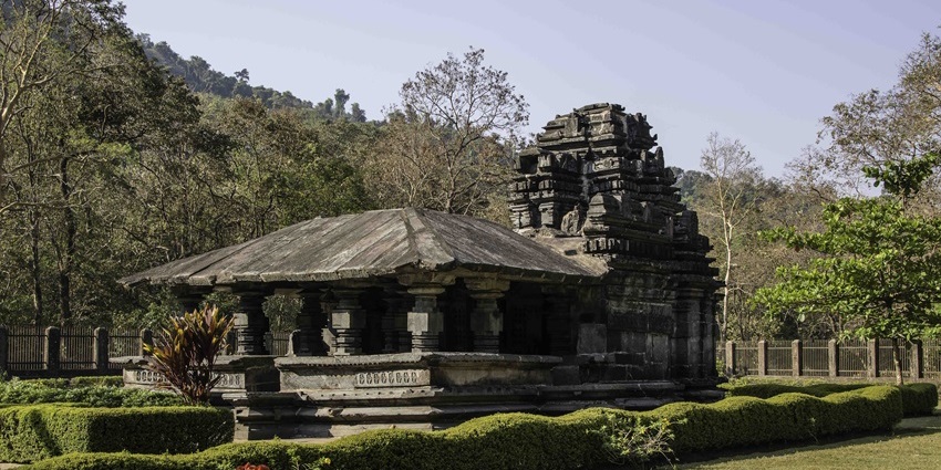 Wide-angle view of Shri Damodar Temple, surrounded by lush greenery