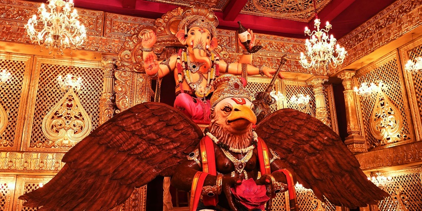 A picture of a decorated pandal of Lord Ganesh with an idol sitting on a bird