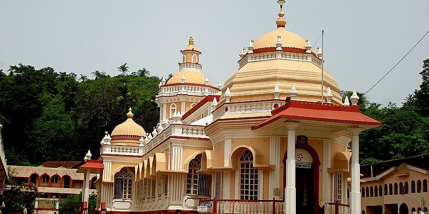 Shri Mangesh Temple in Goa, featuring ornate architecture and lush greenery around it.