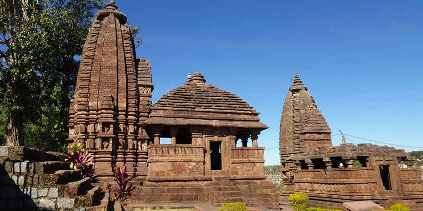 A picture of a historical Shiva temple in Delhi with intricate carvings and a garden in front