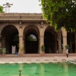 A breathtaking frontal view of Sidi Saiyyed Mosque in Gujarat with a pond in front.