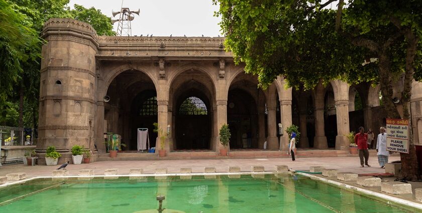 A breathtaking frontal view of Sidi Saiyyed Mosque in Gujarat with a pond in front.