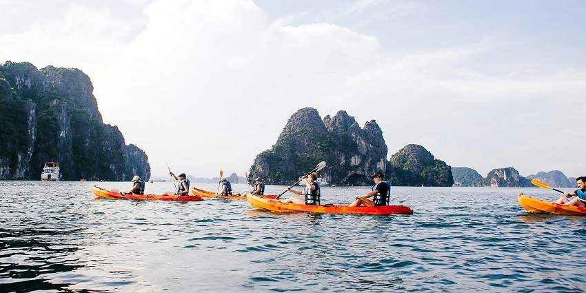 A scenic view of people boating on the shimmering waters of Ha Long Bay in Vietnam.
