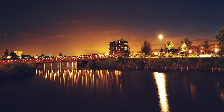 A view of a bridge across water Sinq Beach Club adorned with beautiful shining lights.