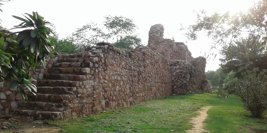 A picture of a stairway at a fort made in the traditional style with a garden area nearby the stairs