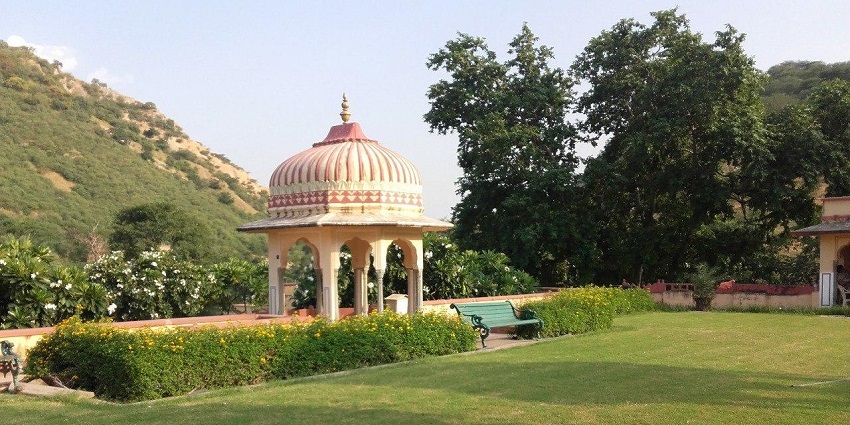 A serene Mughal-style garden with lush greenery, fountains, and charming pavilions.