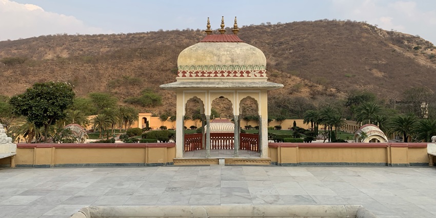 A picture of a decorated bench in a garden, with views of lush mountains in the background