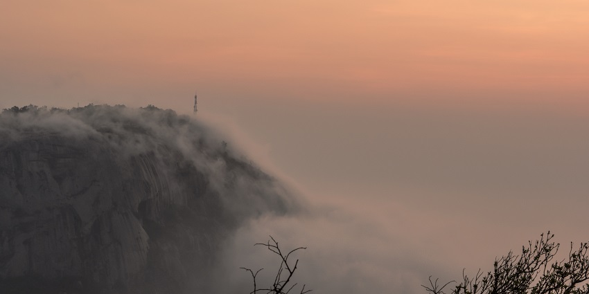 An early morning view of the hills surrounded by foggy clouds before the sunrise
