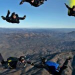 A breathtaking view of a few people enjoying sky diving in the air during the daytime.