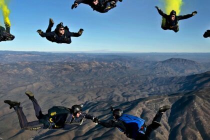 A breathtaking view of a few people enjoying sky diving in the air during the daytime.