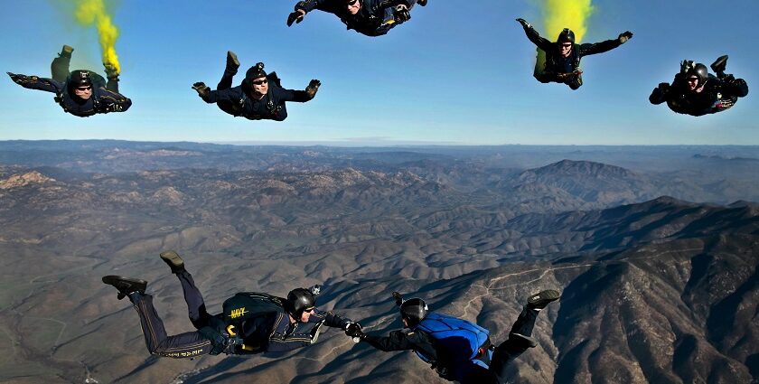 An image of people with a black suit and bags experiencing exciting skydiving in Pattaya.