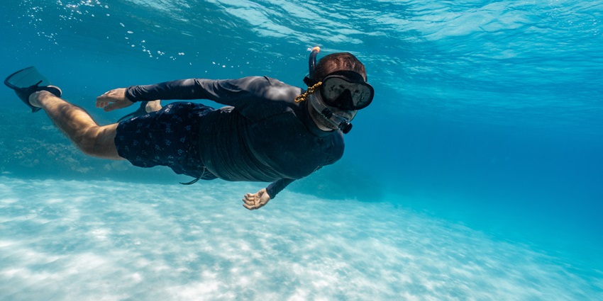 Underwater view of a girl snorkelling in the crystal clear turquoise water of the sea