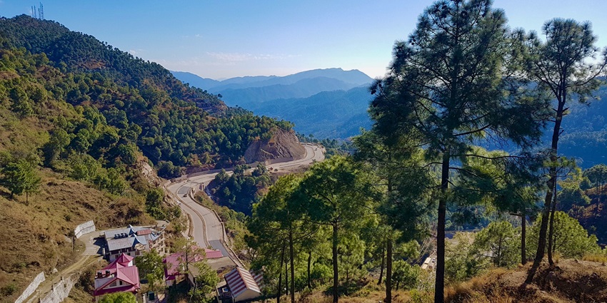 Scenic view of Solan in twisty roads surrounded by green mountains and houses on the hills