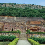 A panoramic view of Sonbhandar Caves in Rajgir, Bihar surrounded by greenery