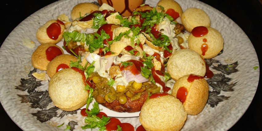 Aloo tikki chaat served with mint and tamarind chutney then sprinkled with pomegranates and sev
