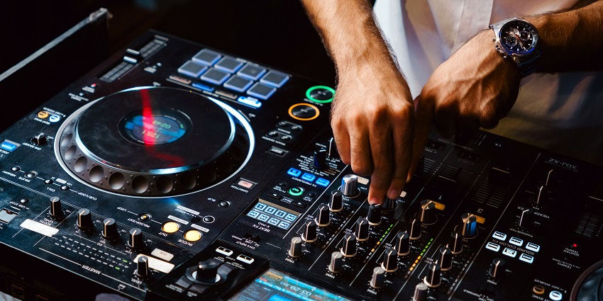 A Dj playing music on their DAW at a club in Calangute