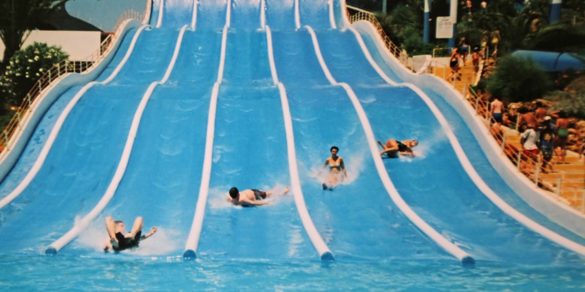 A picture of a wave pool in a water park with people enjoying a swim and the challenges of the pool