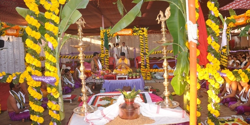 A picture of a decorated mandap with an idol of Lord Ganesha places in the centre being worshipped