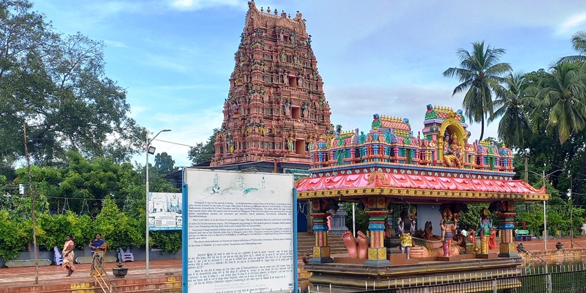 A view of the majestic Gopurama of a Shiva temple with a pond in front of the temple complex
