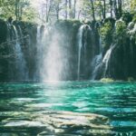 A breathtaking view of a waterfall surrounded by lush greenery during the daytime.