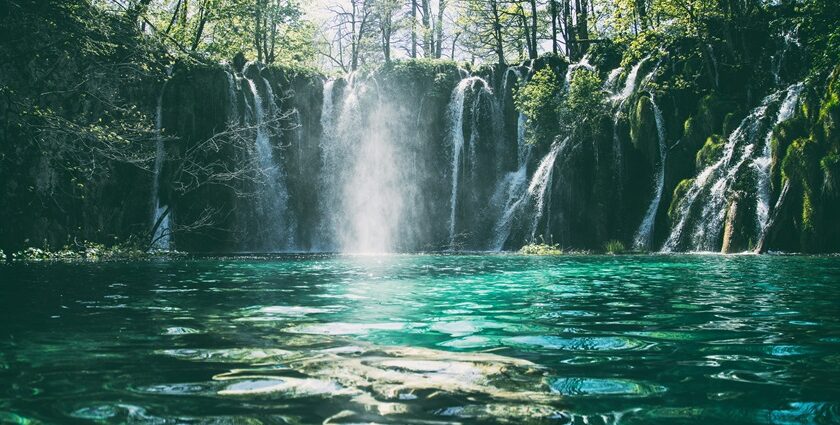 A breathtaking view of a waterfall surrounded by lush greenery during the daytime.