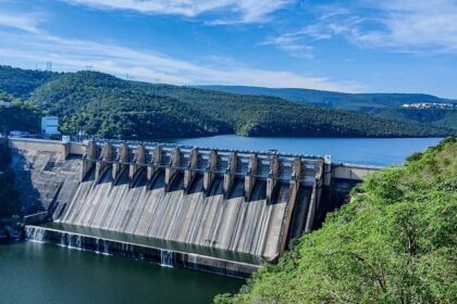 A stunning view of the massive dam surrounded by lush greenery and hills.